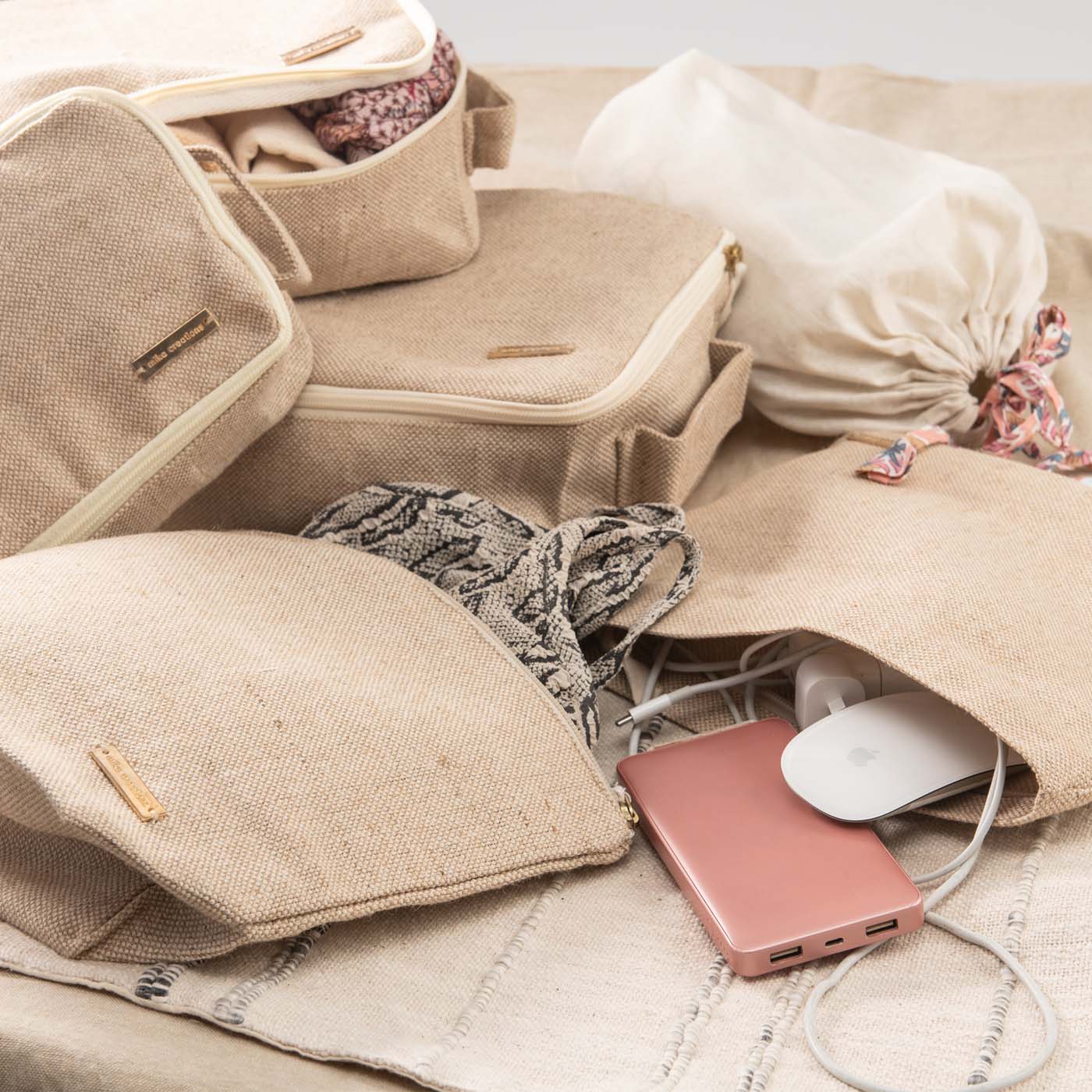 Set of 6 travel packing cubes in beige jute and cotton, including cubes, wet bag, tech bag, and shoe/laundry bag.