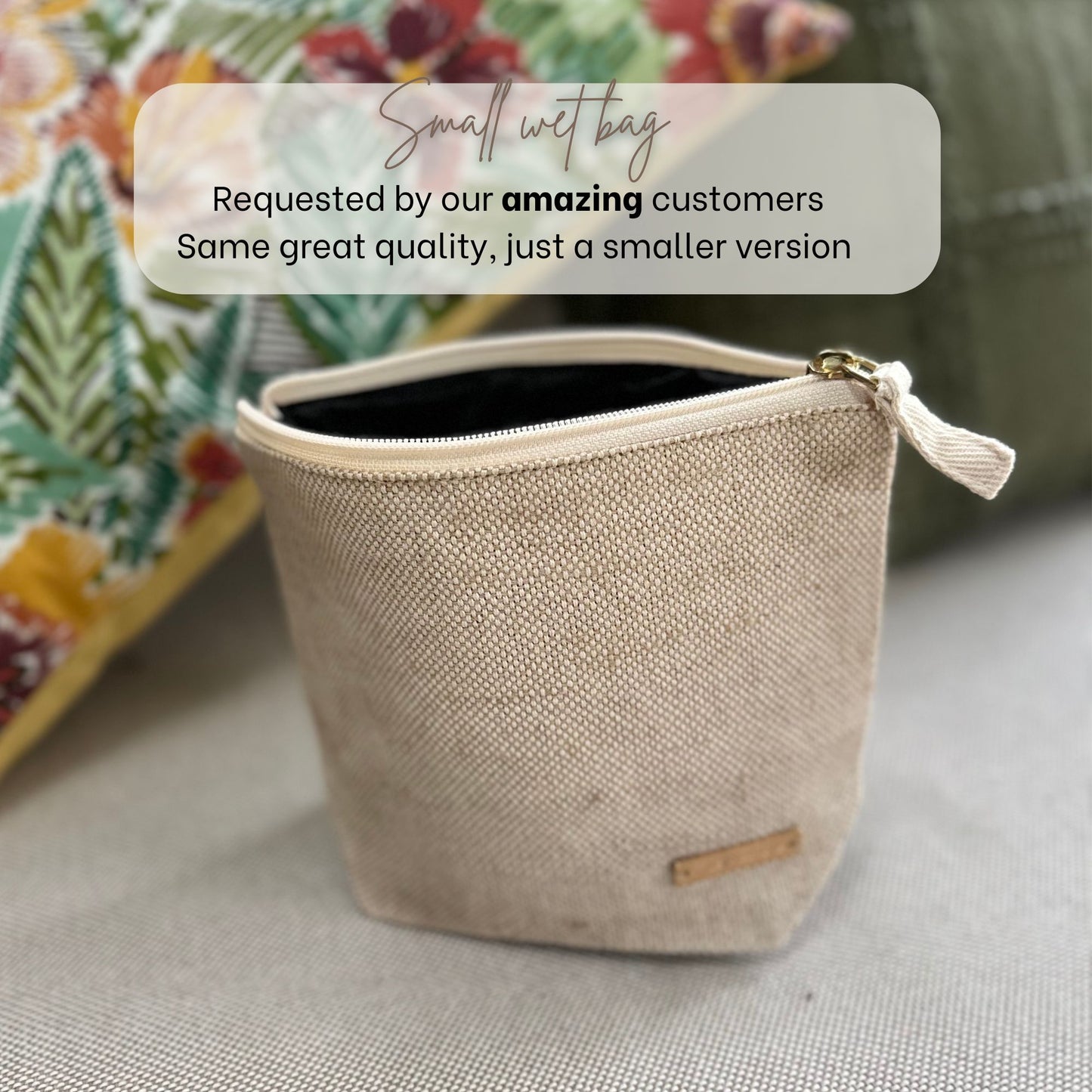 Small beige open wet bag with a gold zipper on a neutral background