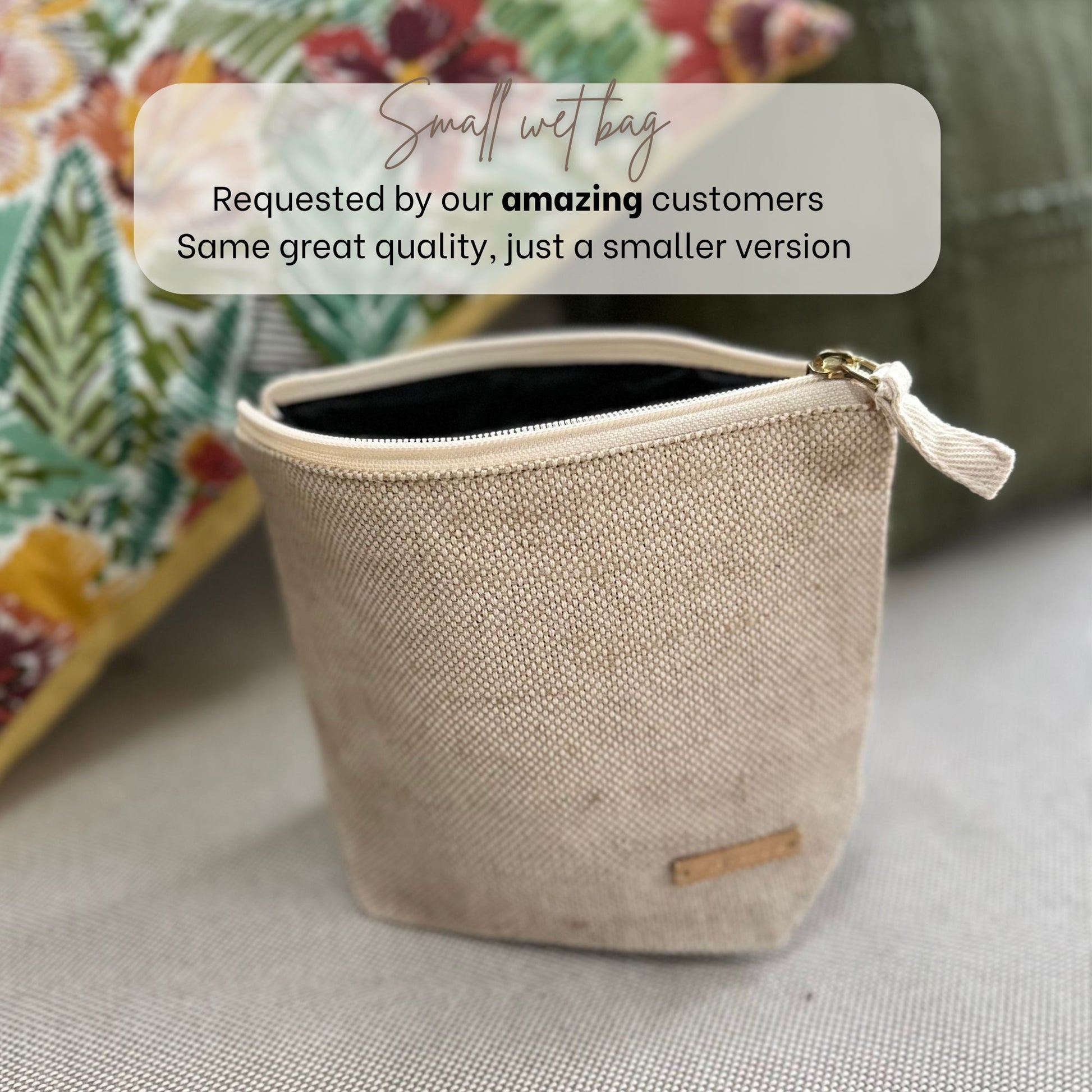 Small beige open wet bag with a gold zipper on a neutral background