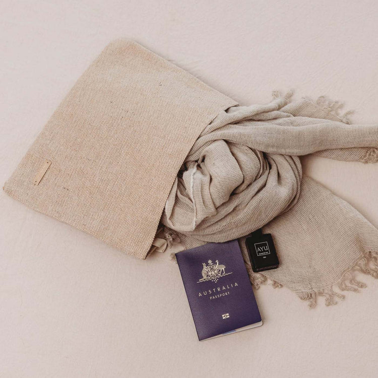 Passport in an Eco-friendly beige travel tech pouch made from Juco, designed to organise electronics or serve as a stationery/pencil case.