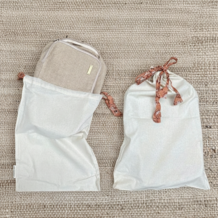 Drawstring bags on a textured beige surface